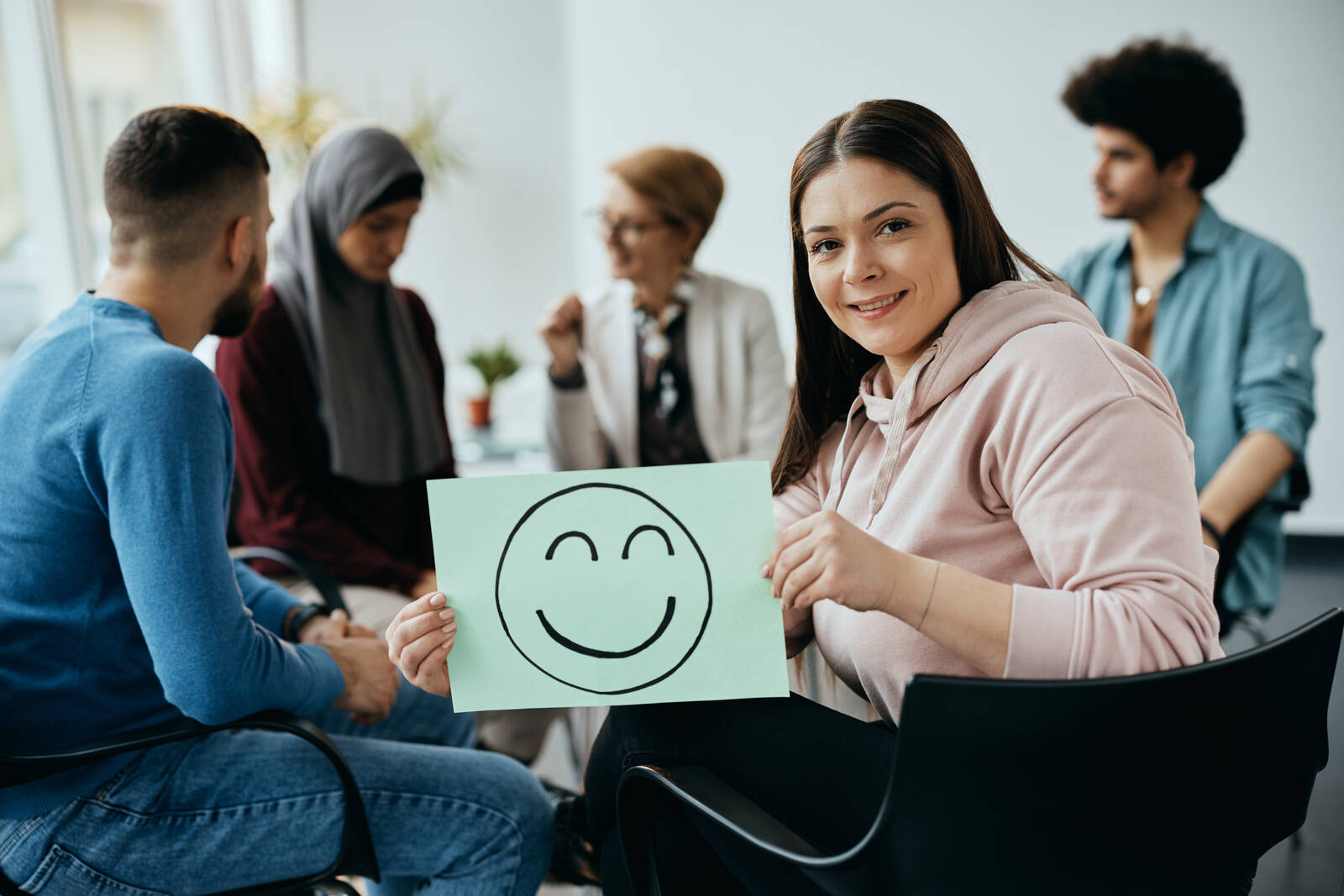 Grupo de pessoas em sessão de apoio, mulher sorrindo