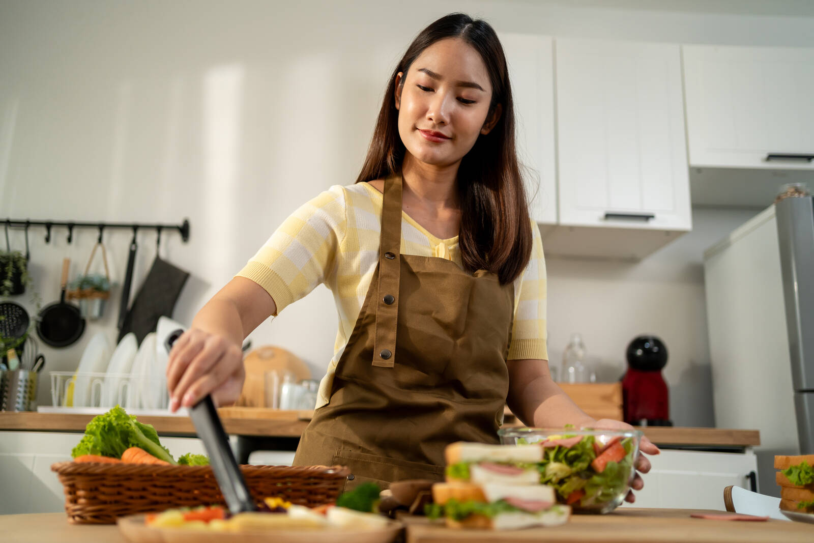 Mulher preparando salada na cozinha