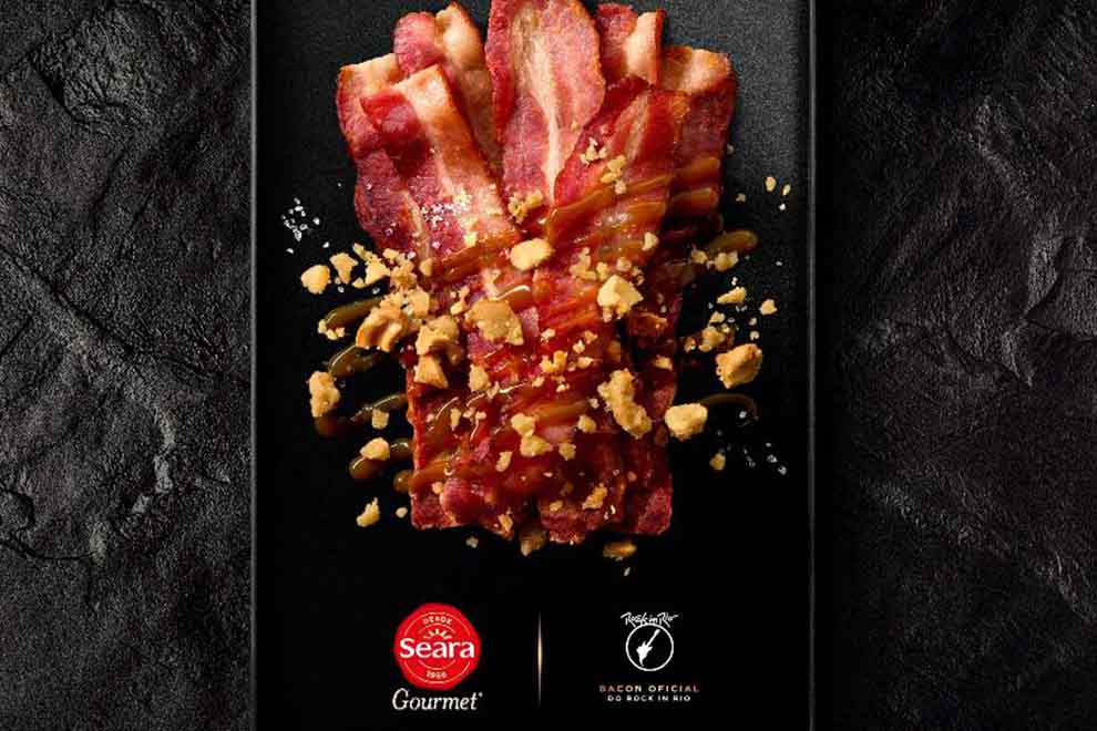 pedaços de bacon com molho de caramelo com flor de sal em cima de uma mesa escura