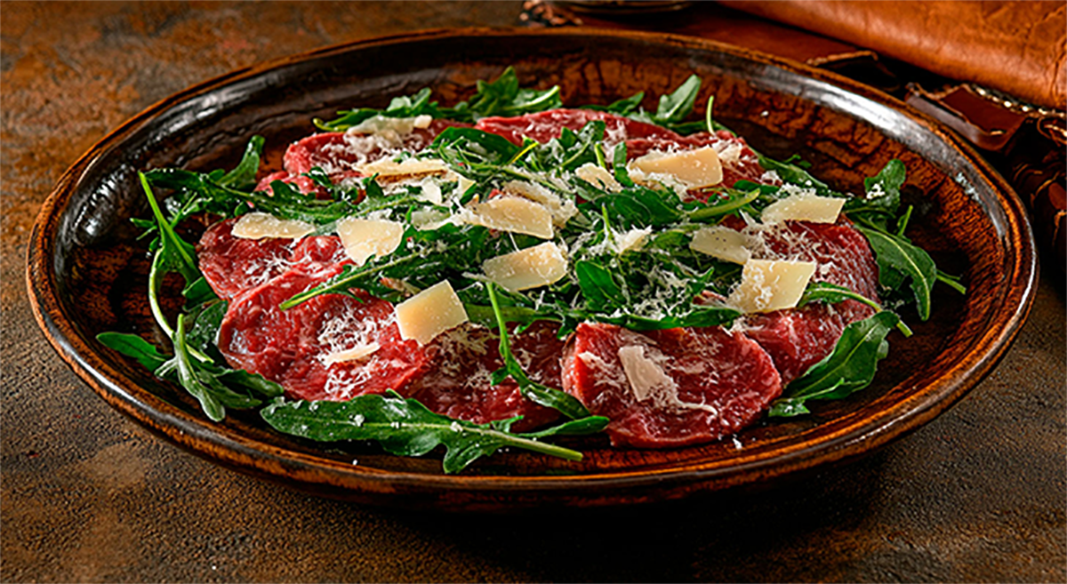 Carpaccio de filé mignon com lascas de parmesão e rúcula selvagem