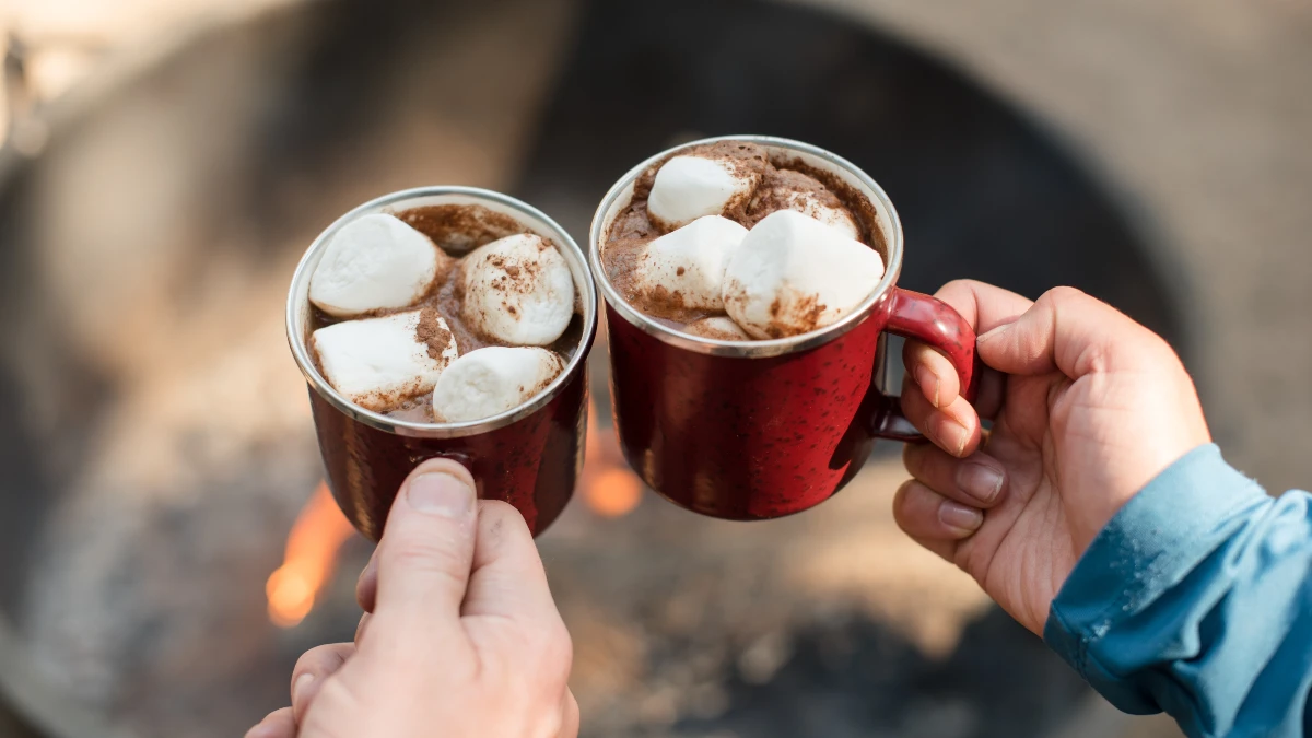 Chocolate quente servido com marshmallows em uma xícara vermelha. 