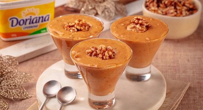 Creme de nozes com doce de leite servido em tacinhas transparentes.