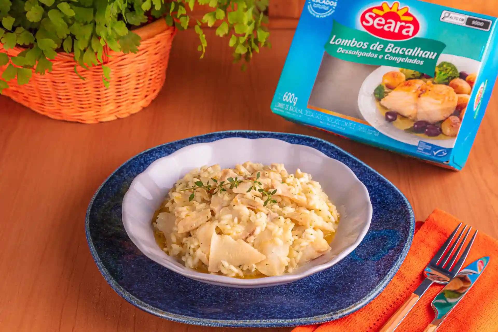 Risoto de bacalhau servido em um prato branco. 