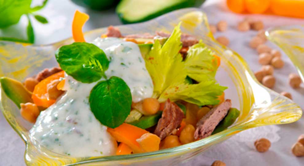Salada tropical feita com folhas de alface e rúcula, pedaços de manga, grão de bico e cenoura.